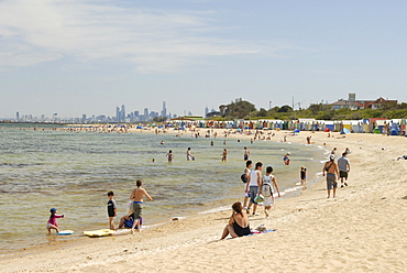 Beach scene with beach huts at Brighton Beach, Brighton, and in background skyscrapers of City of Melbourne, Victoria, Australia, Pacific