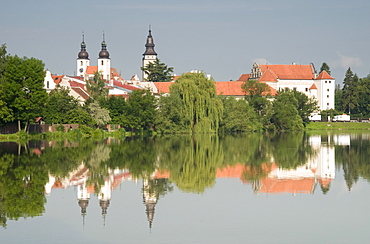 Telc Chateau and residential buildings reflected in Stepnicky Pond, Telc, Jihlava Region, Czech Republic, Europe