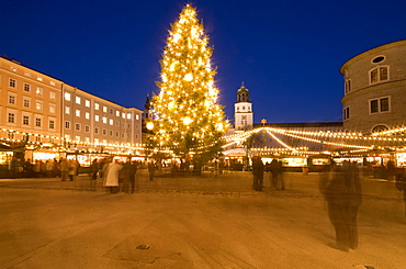 Christmas tree and stalls of historical Salzburg Christkindlmarkt (Christmas market) with Glockenspiel building, Residenzplatz at twilight, Salzburg, Austria, Europe