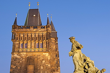 Gothic Old Town Bridge Tower and Baroque statue of St. Ivo (Bishop of Chartres) at twilight, Charles Bridge, Old Town, UNESCO World Heritage Site, Prague, Czech Republic, Europe