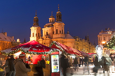 Snow-covered Christmas Market and Baroque St. Nicholas Church, Old Town Square, Prague, Czech Republic, Europe