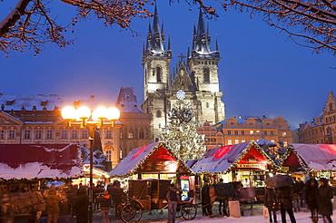 Merry Christmas sign at snow-covered Christmas Market and Tyn Church, Old Town Square, Prague, Czech Republic, Europe