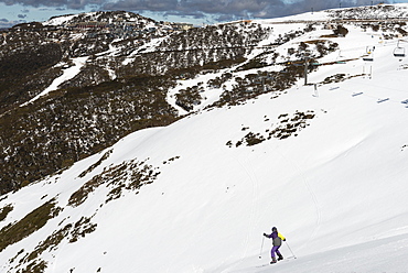 Young skier skiing down The Chute and Mount Hotham Village, Mount Hotham, Victoria, Australia, Pacific