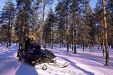 Woman driving snowmobile near Lulea, Lapland, Sweden, Scandinavia, Europe