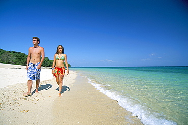 Couple walking on sandy beach, Chapera island (Contadora), Las Perlas archipelago, Panama, Central America