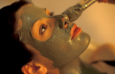 Woman takes a mud bath treatment, Rapolano, Tuscany, Italy