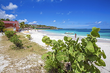 White sand and tourists frame the turquoise Caribbean sea at Long Bay Beach, Antigua and Barbuda, Leeward Islands, West Indies