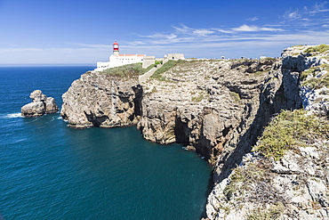 The cliffs and lighthouse overlooks the blue Atlantic ocean at Cabo De San Vicente, Sagres, Algarve, Portugal, Europe