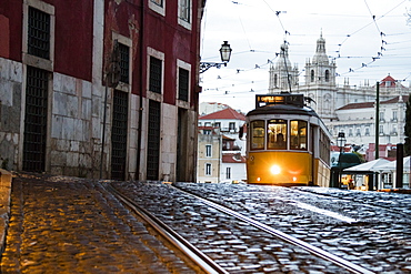 Romantic atmosphere in the old streets of Alfama with the castle in the background and tram number 28, Alfama, Lisbon, Portugal, Europe