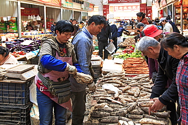 People selling and buying in a traditional market in the center of Kunming, China