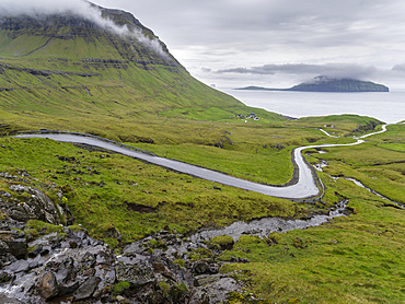 Mountain road to the  Nordradalur at the west coast. Koltur island in the background.  The island Streymoy, one of the two large islands of the Faroe Islands  in the North Atlantic.  Europe, Northern Europe, Denmark, Faroe Islands