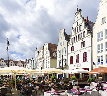 Traditional houses buildt in the middle ages with cafe and restaurant at the  Neuer Markt (new market).  The hanseatic city of Rostock at the coast of the german baltic sea.  Europe,Germany, Mecklenburg-Western Pomerania, June