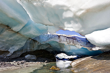 Ice cave and glacier snout of Schlatenkees, source of the creek Schlatenbach. parts of the have collapsed and melted away. Therefore an ice cave with two openings exists. The Schlatenkees is one of the biggest glaciers in Austria and retreating rapidly. Glacial till, moraine debris and roche moutonnee  are visible, Europe, central europe, austria, East Tyrol