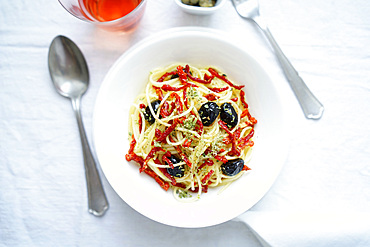 Durum wheat spaghetti pasta seasoned with dried tomatoes, black olives, Pantelleria capers, oregano and extra virgin olive oil, Italy, Europe