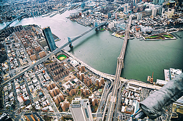 New York City from helicopter point of view. Brooklyn, Manhattan and Williamsburg Bridges with Manhattan skyscrapers on a cloudy day.