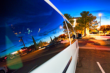 Sunset city reflections on a car side window.