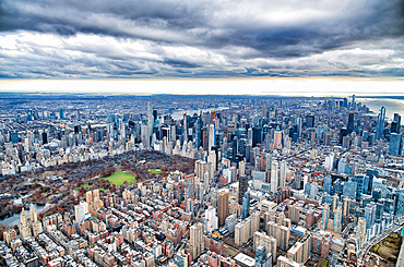 New York City from helicopter point of view. Central Park and Manhattan skyscrapers on a cloudy day, USA