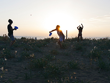 Boys playing racket ball at sunset on the beach, EcoVillage Maremirtilli, Capaccio Paestum, Campania, Italy, Europe