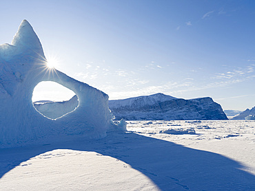 Icebergs frozen into the sea ice of the Uummannaq fjord system during winter in the the north west of Greenland, far beyond the polar circle. North America, Greenland, danish territory