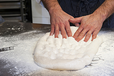 The preparation of a classic focaccia. Italy