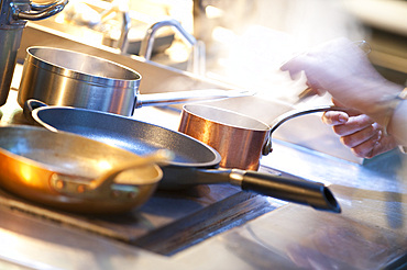 Hands of chefs at the stove; Italy