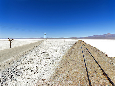 The salt flats Salar de Pocitos in the Argentinian Altiplano. Routa 27 and the railway Salta - Antofagasta is crossing the salt flats. South America, Argentina