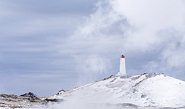 Reykjanesviti lighthouse with steam hovering over the hot springs of the geothermal area Gunnuhver and teh geothermal power plant Sudurnes. europe, northern europe, iceland, February