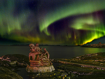 Northern lights over the Mother of the sea, Sassuma Arnaa - a legendary figure in Inuit culture. Sculpure by Christian Rosing in the colonial harbour Nuuk the capital of Greenland during late autumn. America, North America, Greenland, danish terriotory