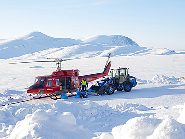 Helicopter on helipad. During winter the helicopter is the only link to the rest of Greenland. The traditional village Kullorsuaq on the shore of the Melville Bay, part of the Baffin Bay, in the far north of Greenland.