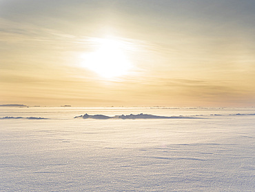 Sunset over the stormy and frozen Melville Bay, part of the Baffin Bay, near Kullorsuaq in the far north of West Greenland.