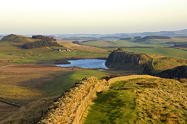 Towards sunset, view east along Hadrians Wall from Windshields Crag to Crag Lough and Hotbank Farm, UNESCO World Heritage Site, Northumberland National Park, Northumbria, England, United Kingdom, Europe