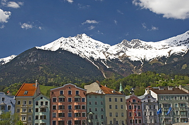 Candy coloured houses with backdrop of mountains in spring snow, Innsbruck, Austria, Europe