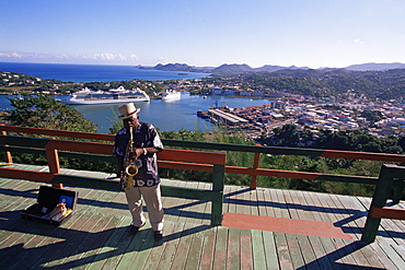 Man playing a saxophone at Morne Fortune, with a view over Castries, St. Lucia, Windward Islands, West Indies, Caribbean, Central America