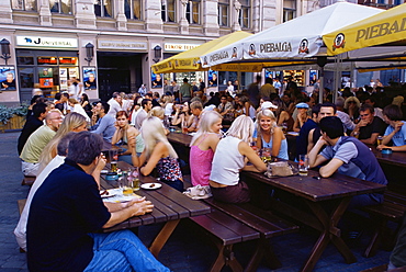 People at an outdoor restaurant in plaza along Kalku iela, Old Town, Riga, Latvia, Baltic States, Europe