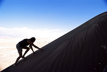 Tourist climbing dunes, Valle de la Luna (Valley of the Moon) (Moon Valley), Atacama Desert, Chile, South America