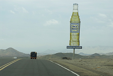 Transport truck on the Pan American highway in northern Peru, South AmericaInca Kola (The National Soda) sign on the side of the road