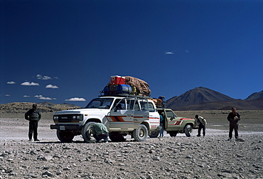 Landcruisers and tourists on jeep tour taking a break on Uyuni salt flat, Bolivia, South America