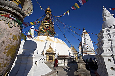 A monk walks clockwise around the buddhist stupa called Swayambhu or Swayambhunath, Kathmandu, Nepal