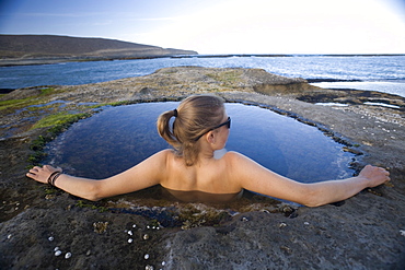 Young woman relaxing in a natural pool, Santa Cruz, Argentina, South America