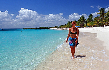 Woman walking on sandy beach, Catalina Island, Dominican Republic, West Indies, Caribbean, Central America