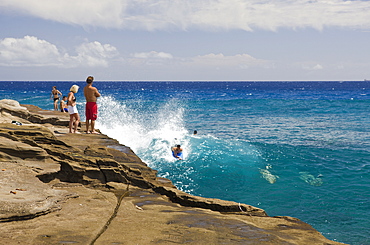 Tourists surfing at Chinawall Rocks at Kawaihoa Point, Oahu, Pacific Ocean, Hawaii, USA