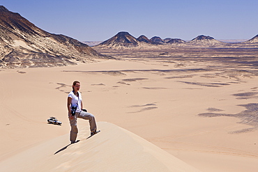 Tourist on 50-Meter Dune in Black Desert, Libyan Desert, Egypt