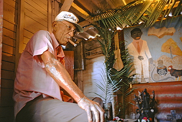 A taita or elder priest of Palo Monte, an African religion with roots in the Congo related to Santeria, in front of his altar, Havana, Cuba