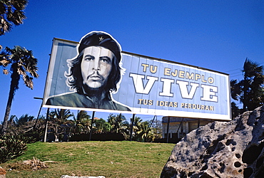 A billboard featuring a portrait of the revolutionary hero Che Guevara with the message He Lives near Playa Santa Maria, Cuba