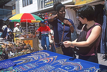 Otavalo, north of Quito is one of Latin Am's most famous markets for textiles, crafts and produce foreign students buying jewelry, Quito, Ecuador