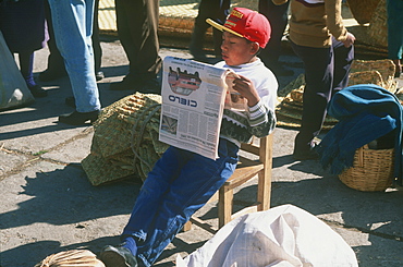 Saquisili south of Quito is one of Latin America's most important indigenous markets young boy reading newspaper, Quito, Ecuador