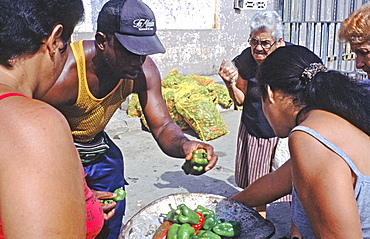 Crowd of customers buying peppers at an outdoor market in the town of Baracoa in eastern Cuba, Cuba