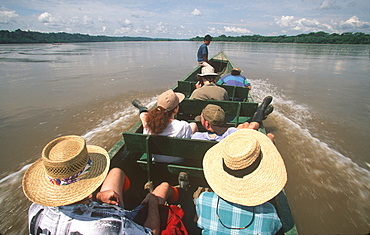 Amazon Basin, Napo River (tributary) La Selva Jungle Lodge, naturalists in dugout canoe on the Napo passing through rainforest, Amazon, Ecuador