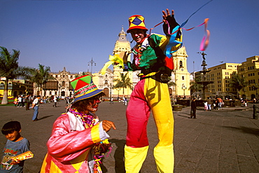 Street entertainers on stilts perform in the Plaza de Armas with the Cathedral, built in 1564-1625, (rebuilt in the 18thc) beyond, Colonial Architecture, Lima, Peru