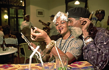 A flamboyant couple (professional dance duo called Danzamor) enjoying a cigar in a bar in Habana Vieja, Havana, Cuba